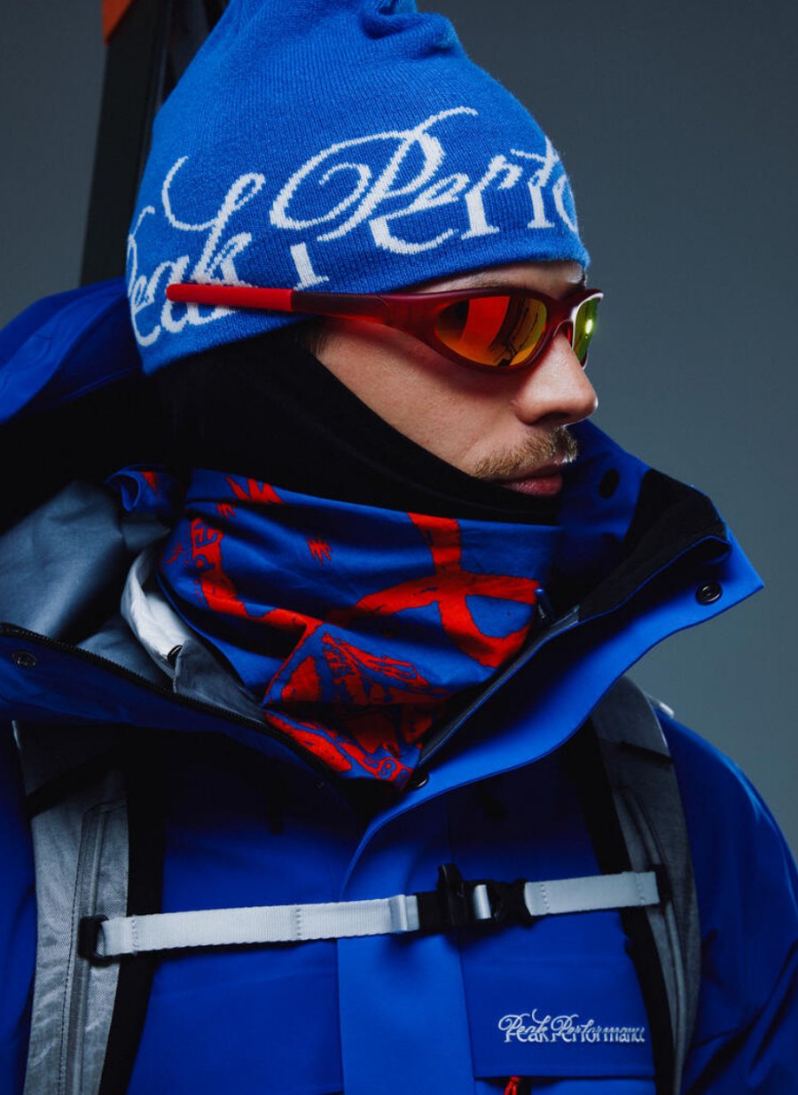 Model med Peak Performance 40Y hue, skibriller og blå GORE-TEX skijakke